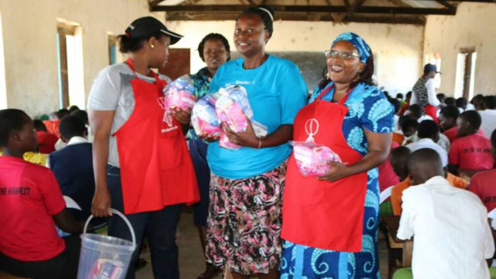 Stella Nyanzi (re) verteilt Binden in einer Schule. Foto: Barigye Ambrose