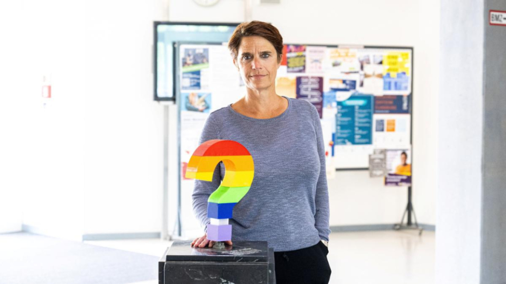 Pressesprecherin Kathrin Fischer mit der neuen Skulptur, dem Regenbogen-Fragezeichen. - Foto: Benjamin Bolte